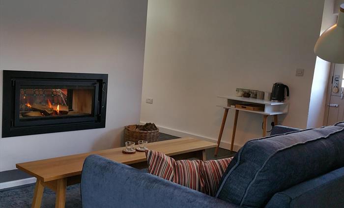 Sofa facing a coffee table and a 2 sided fireplace